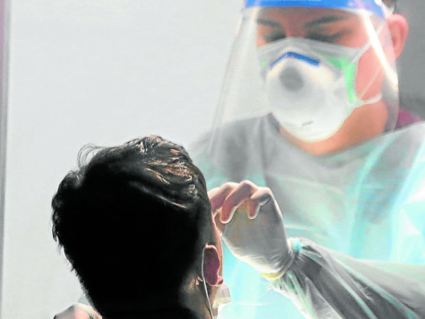 NASALSWAB A health worker performs a swab test. —FILE PHOTO/GRIG C. MONTEGRANDE